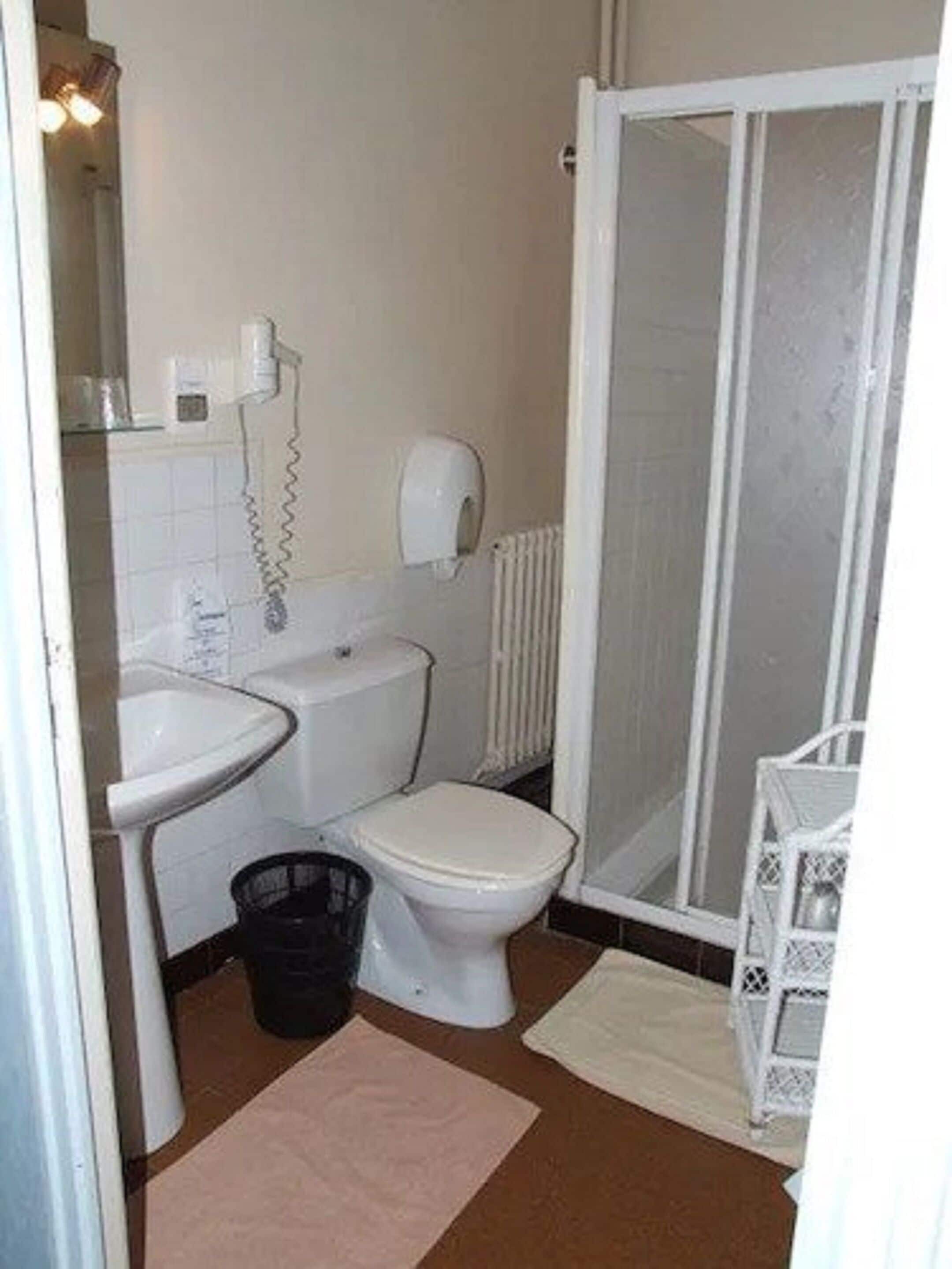 Ein kleines Badezimmer mit Toilette, Waschbecken und Dusche.