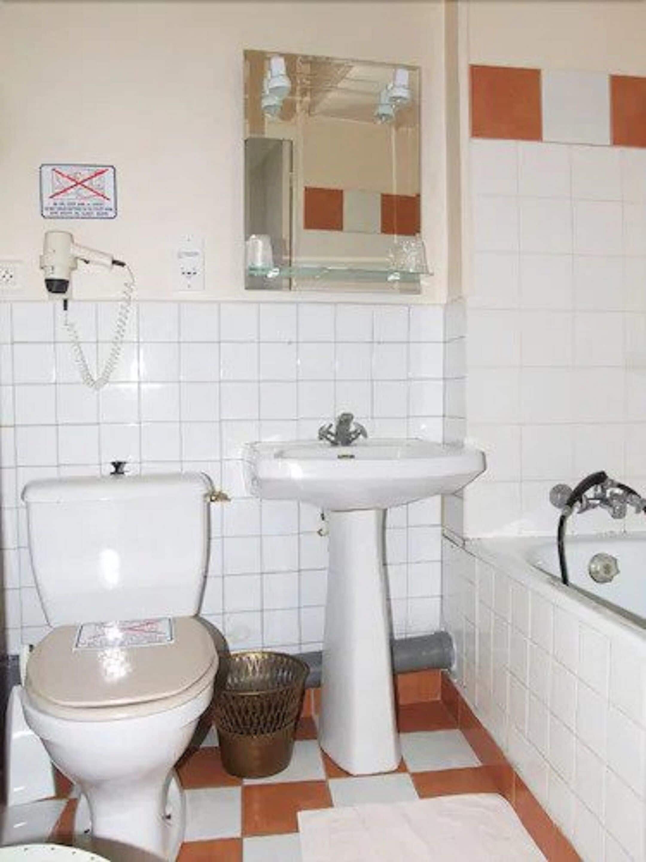 Un baño con inodoro, lavamanos y bañera.