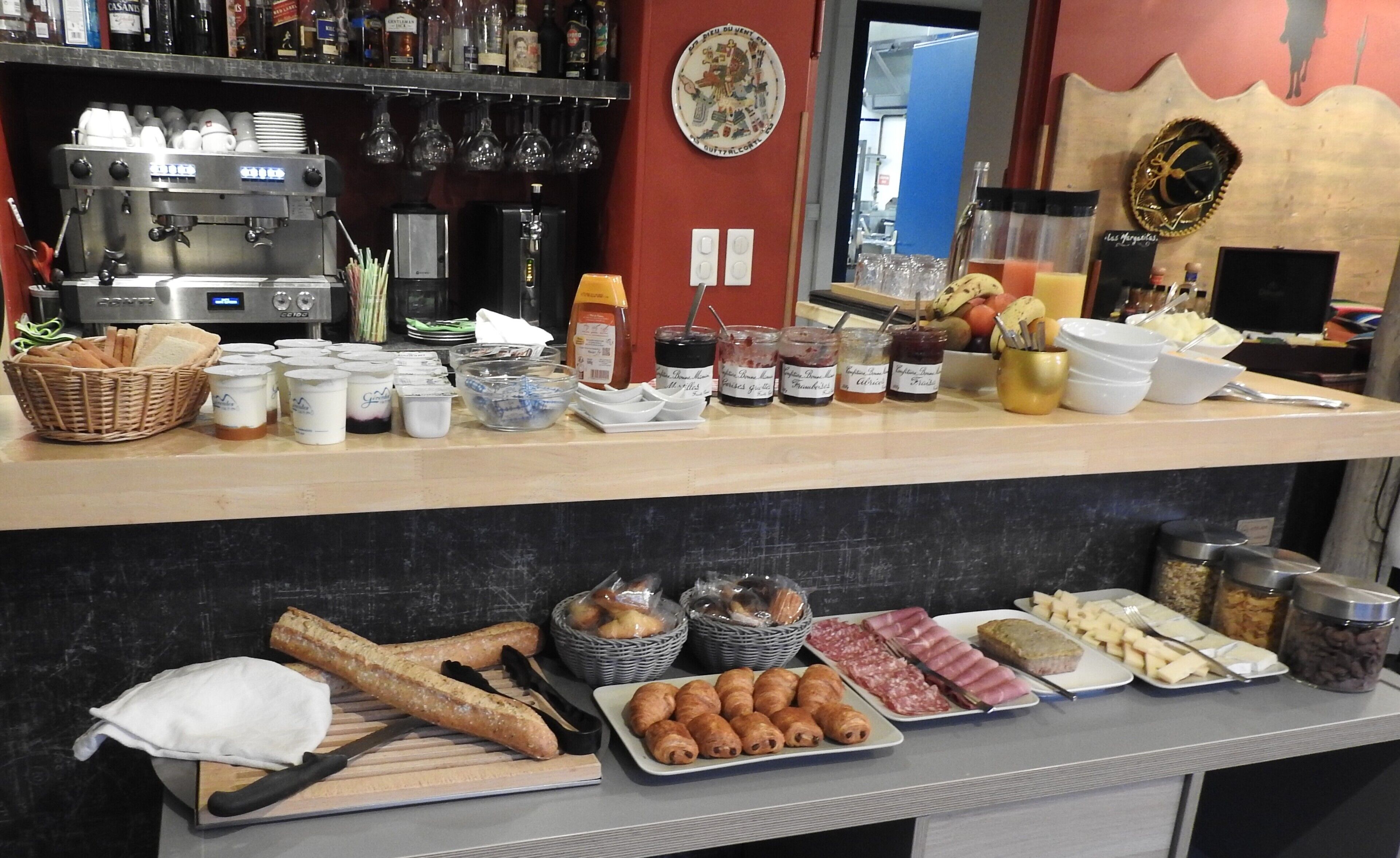 Un bufé de desayuno con diversos alimentos, salsas y una máquina de café.
