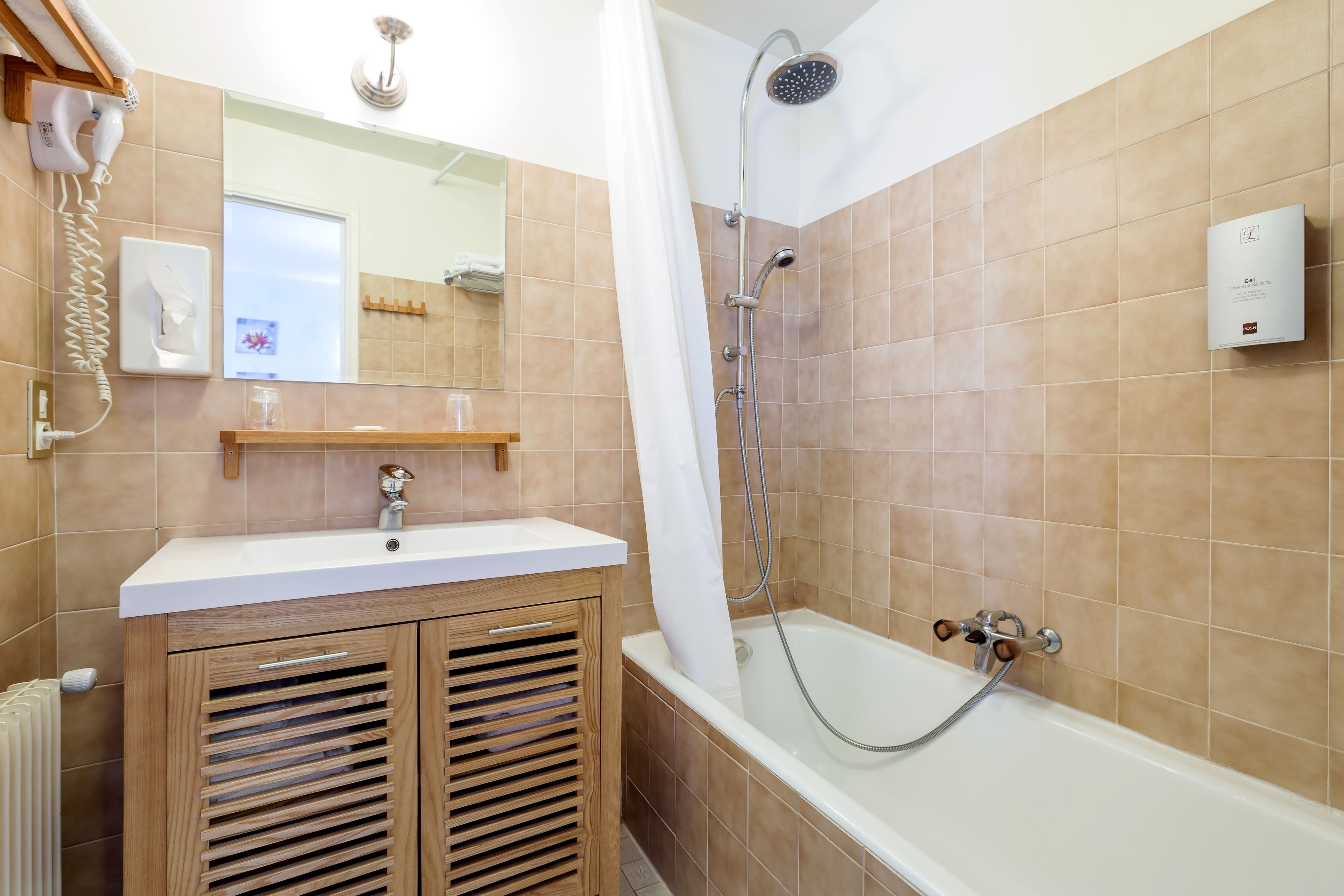 A bathroom with a sink, mirror, shower, and towel rack.