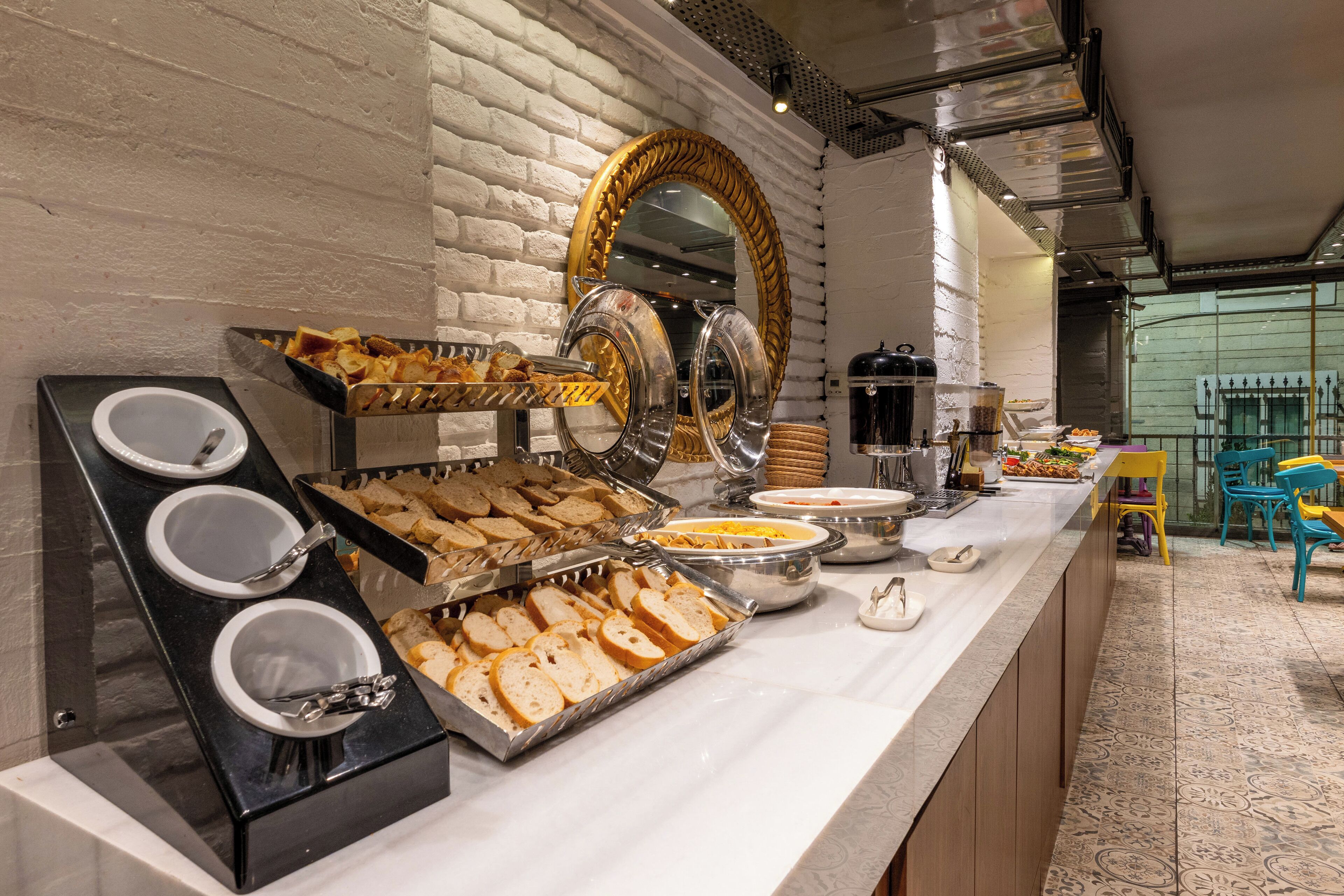 A buffet setup with various food items and a mirror.