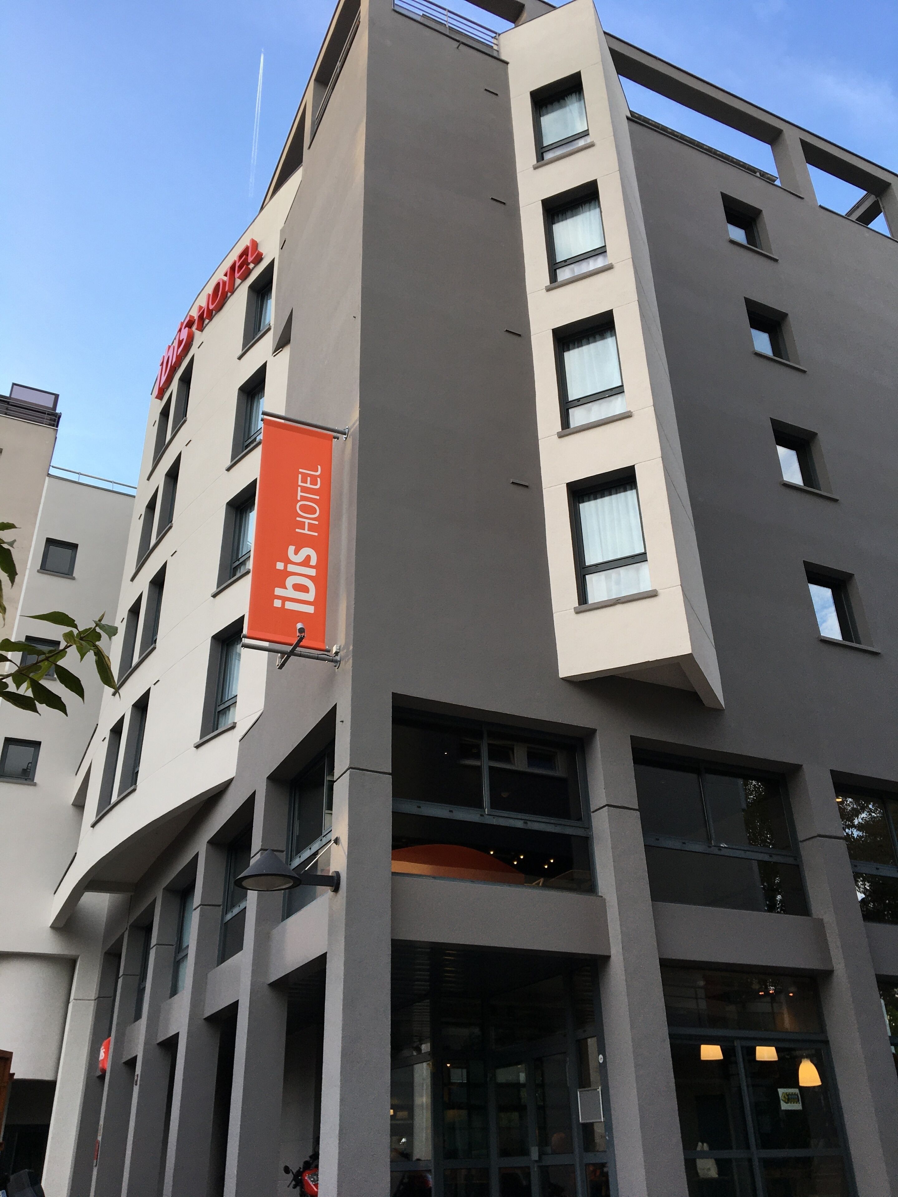 Un moderno edificio de hotel con un llamativo letrero rojo que indica que es un hotel.
