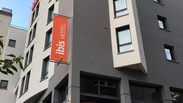 Un moderno edificio de hotel con un llamativo letrero rojo que indica que es un hotel.