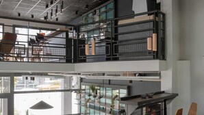 Un intérieur moderne avec une mezzanine, un espace de travail ouvert et un coin repas agrémenté d’un escalier.