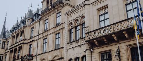 A historic building with ornate architectural details, including multiple balconies and a grand staircase.