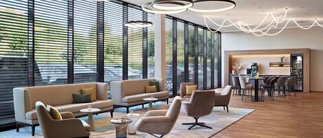 A modern lounge area with sofas, chairs, and a dining table.
