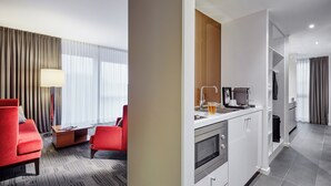 Una habitación de hotel moderna con comedor, cocina y sala de estar.