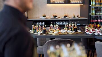 Een eettafel met diverse gerechten en drankjes, waaronder spiezen en glazen wijn.