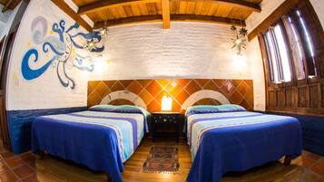 A room with two beds, a mural on the wall, and a wooden ceiling.