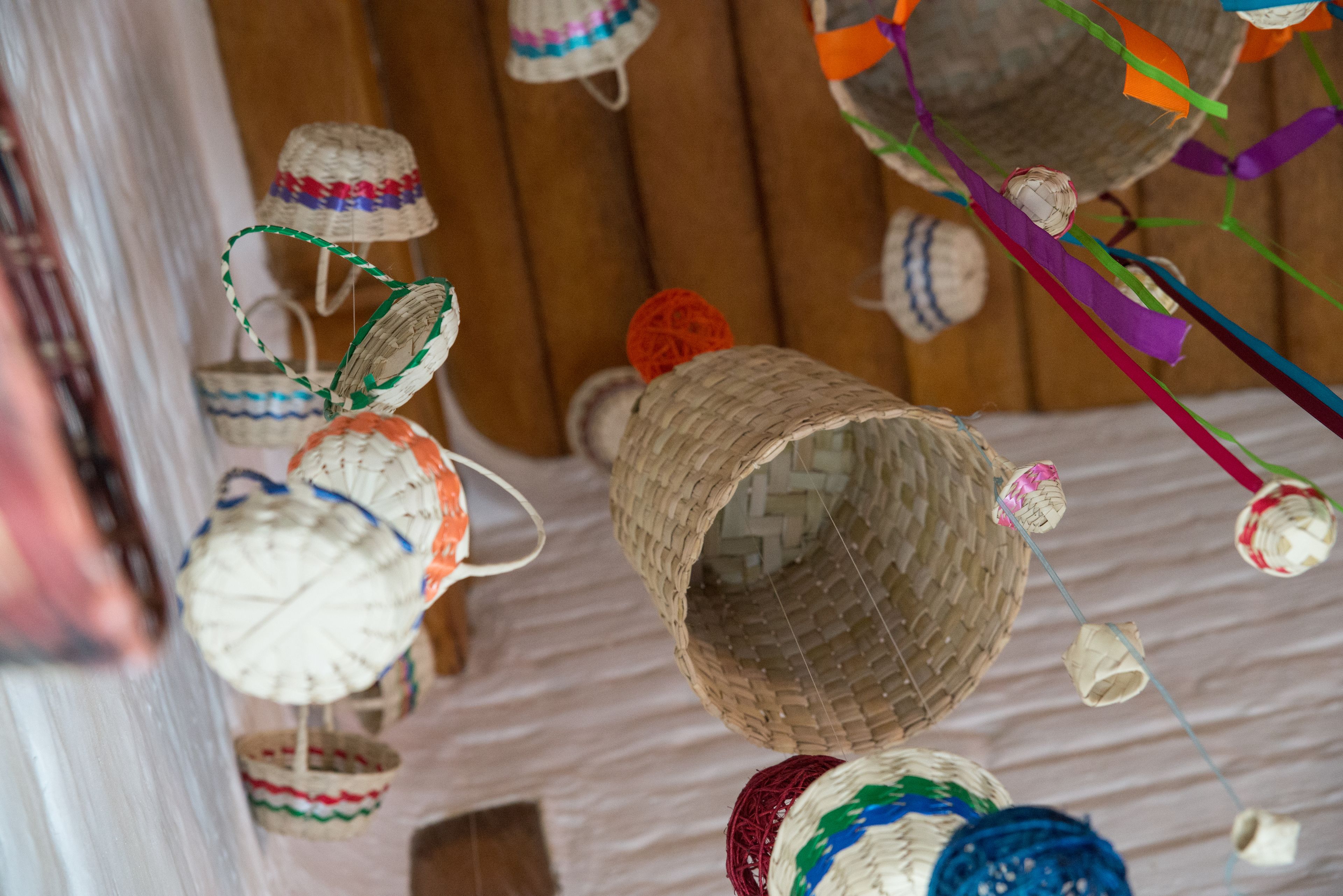 A collection of woven baskets hanging on a wooden wall.