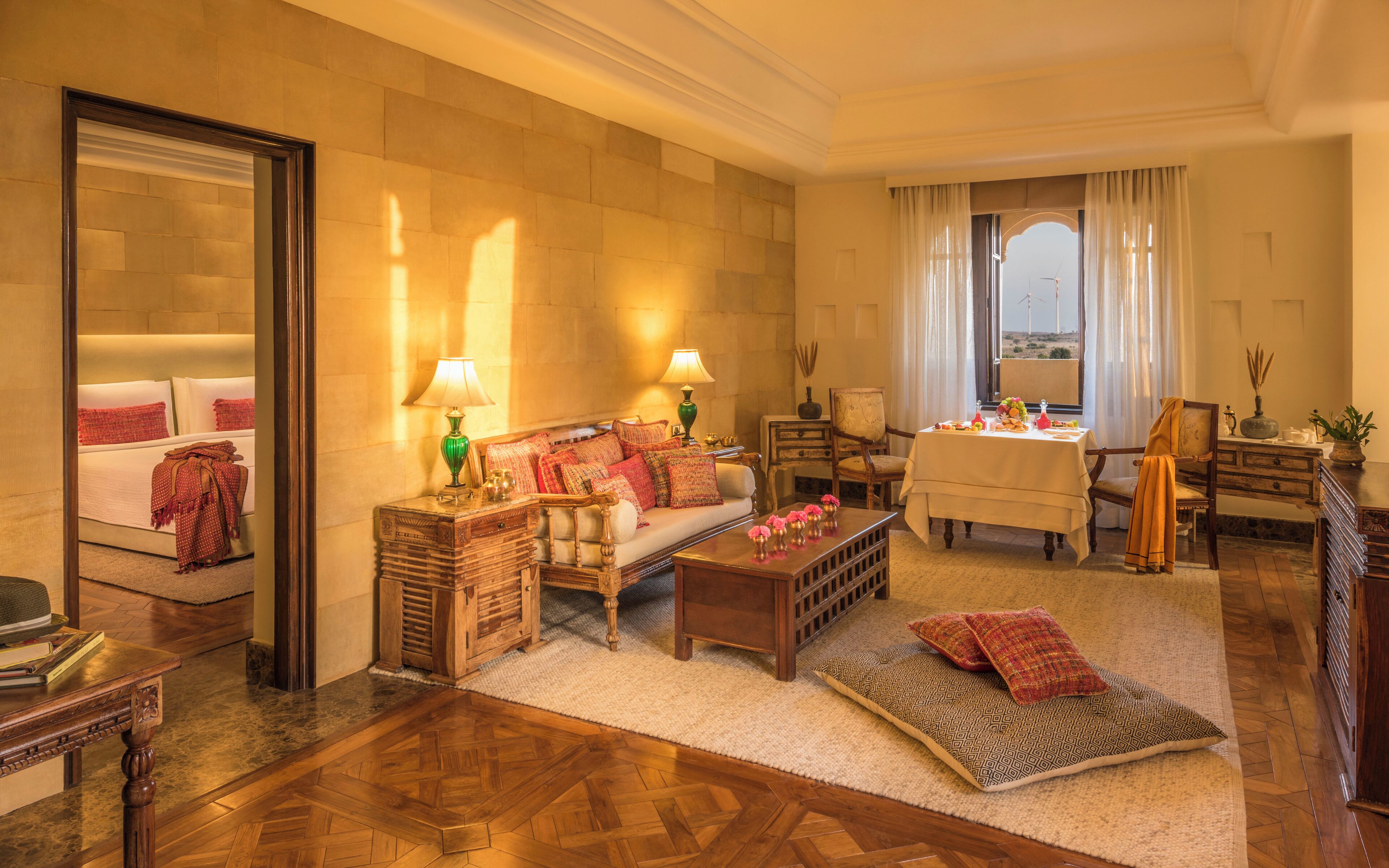 A well-appointed living room with a sofa, armchairs, a coffee table, and a dining table set for a meal.