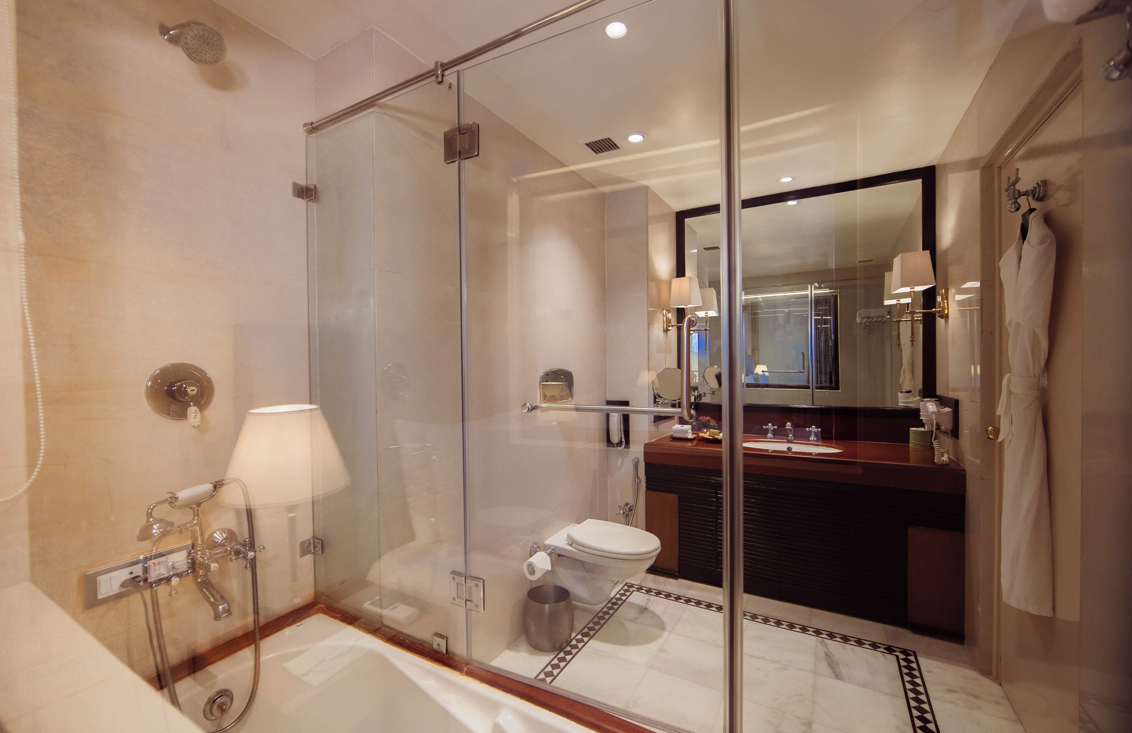 Une salle de bain moderne avec une douche à parois de verre, des toilettes séparées et un meuble-lavabo avec un miroir.