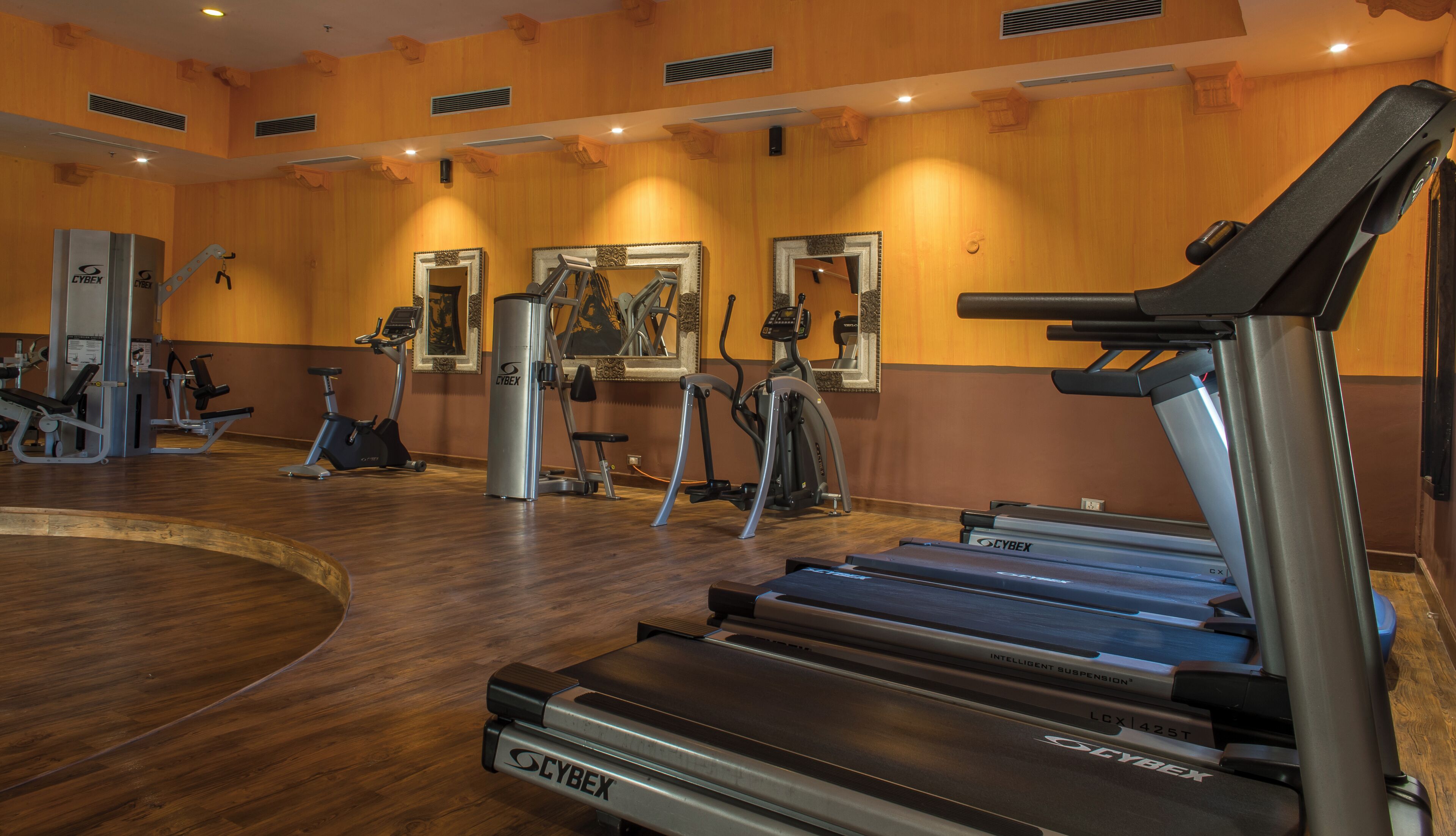 A gym with treadmills, elliptical machines, and weight equipment.