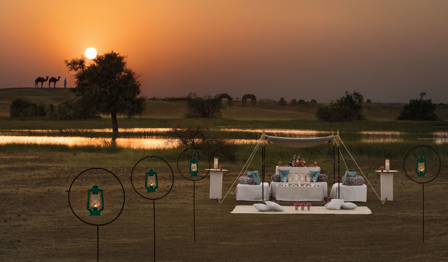Un entorno romántico al aire libre con un área de comedor bajo una cubierta, rodeado de naturaleza y vistas del atardecer.