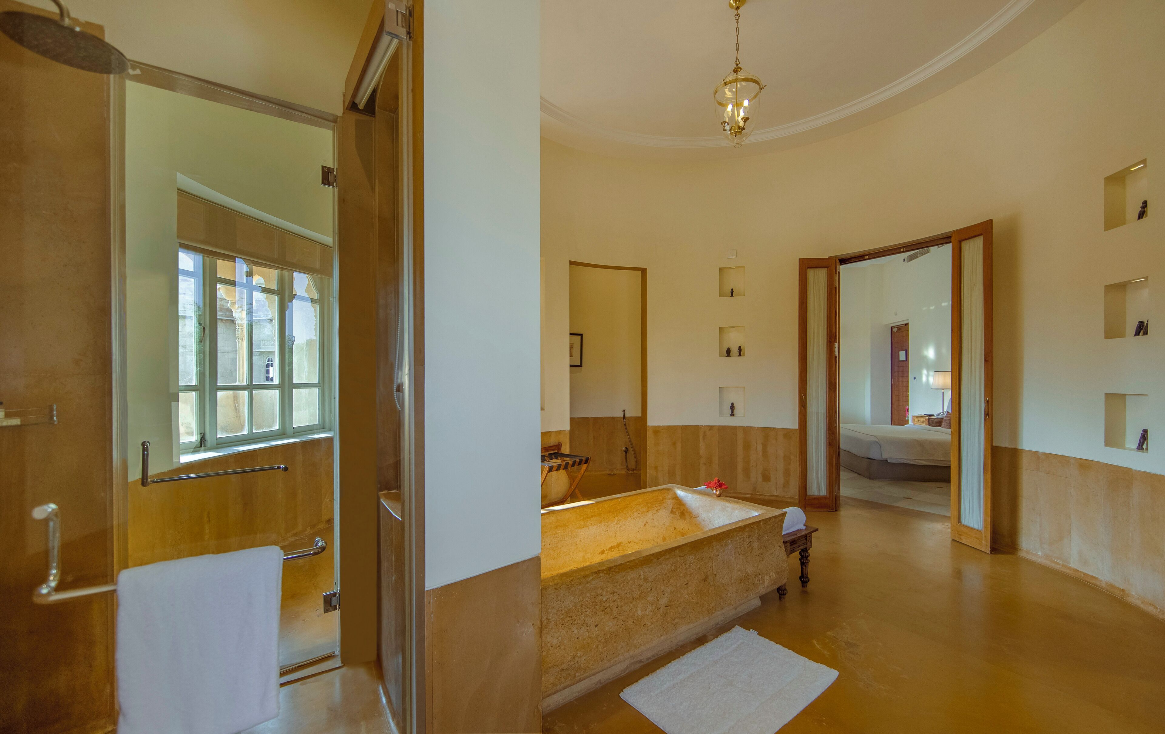 A hotel room with a large mirror, a bathtub, a shower, and a bed.