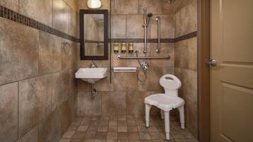 A bathroom with a sink, mirror, toilet, and shower.