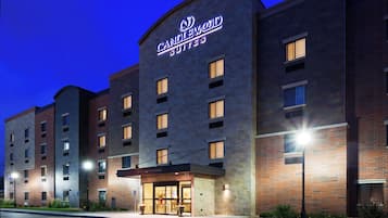 A hotel with a prominent sign, multiple windows, and a well-lit entrance.