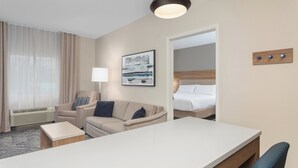 Une chambre d’hôtel avec un lit, un canapé, un bureau et une lampe.