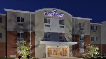 A hotel with a modern facade, a prominent entrance with glass doors, and a sign indicating it is a Candlewood Suites.