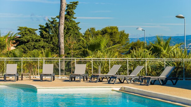 A swimming pool with lounge chairs and a view of the surrounding landscape.