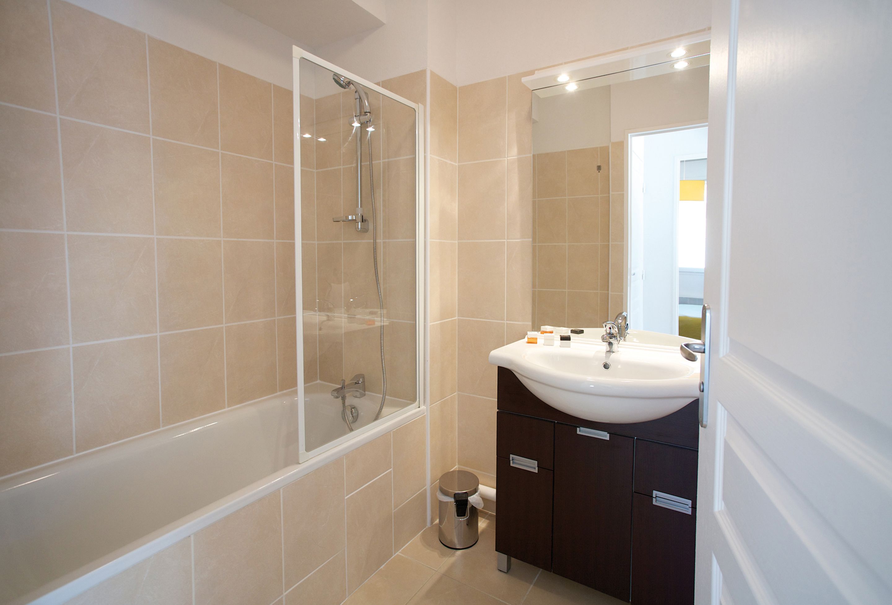 Un baño moderno con bañera, ducha, lavabo y tocador.