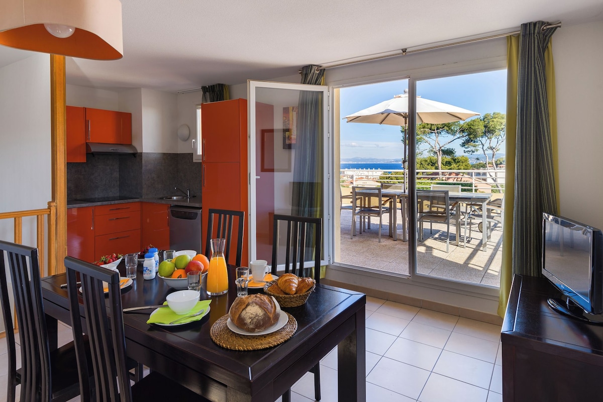 A dining area with a table set for breakfast, a TV, and a view of the outdoors.