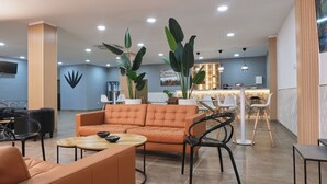 A modern lobby with a sofa, chairs, a coffee table, and a reception desk. - Hotel Aloe Emira NKC (Nouakchott)