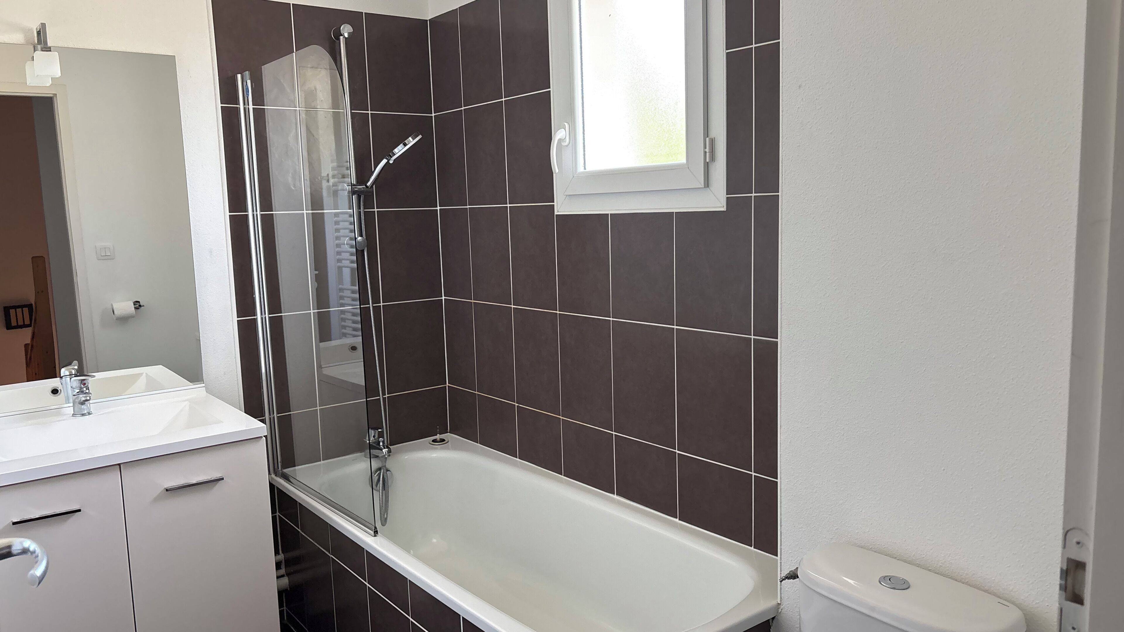 A bathroom with a bathtub, a shower, a sink, and a toilet.
