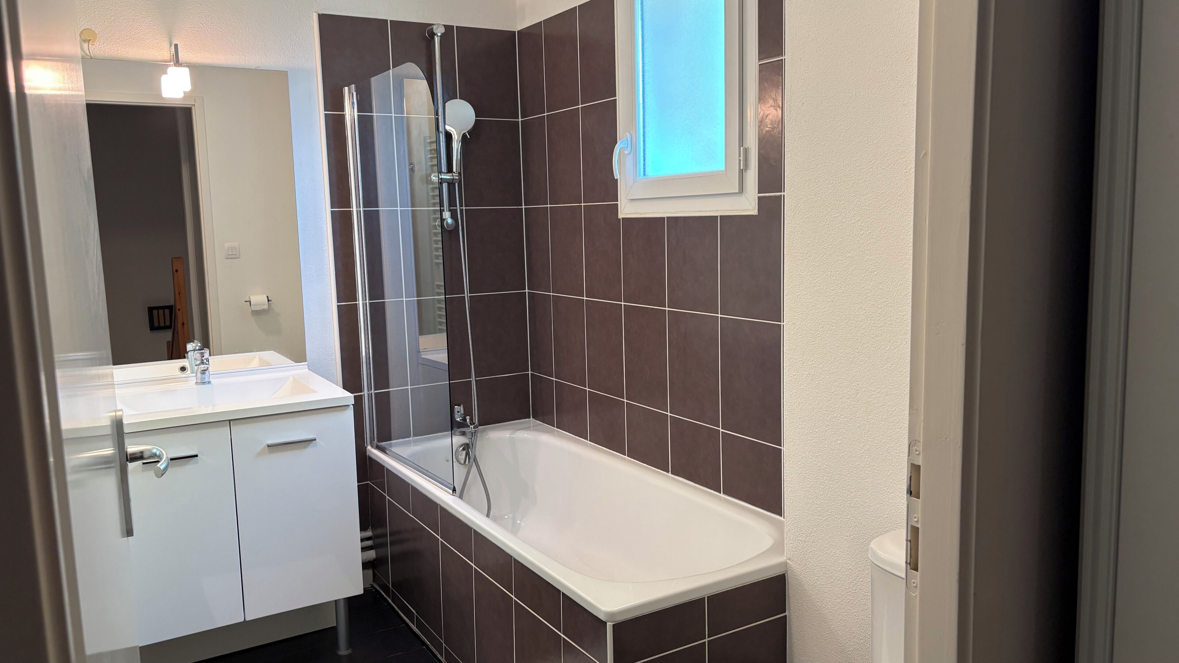Ein Badezimmer mit Badewanne, Dusche, Waschbecken und Spiegel.