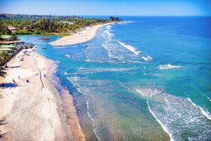 A beach with clear blue waters, a sandy shore, and a few people. - Kombo Beach Resort (Serrekunda)