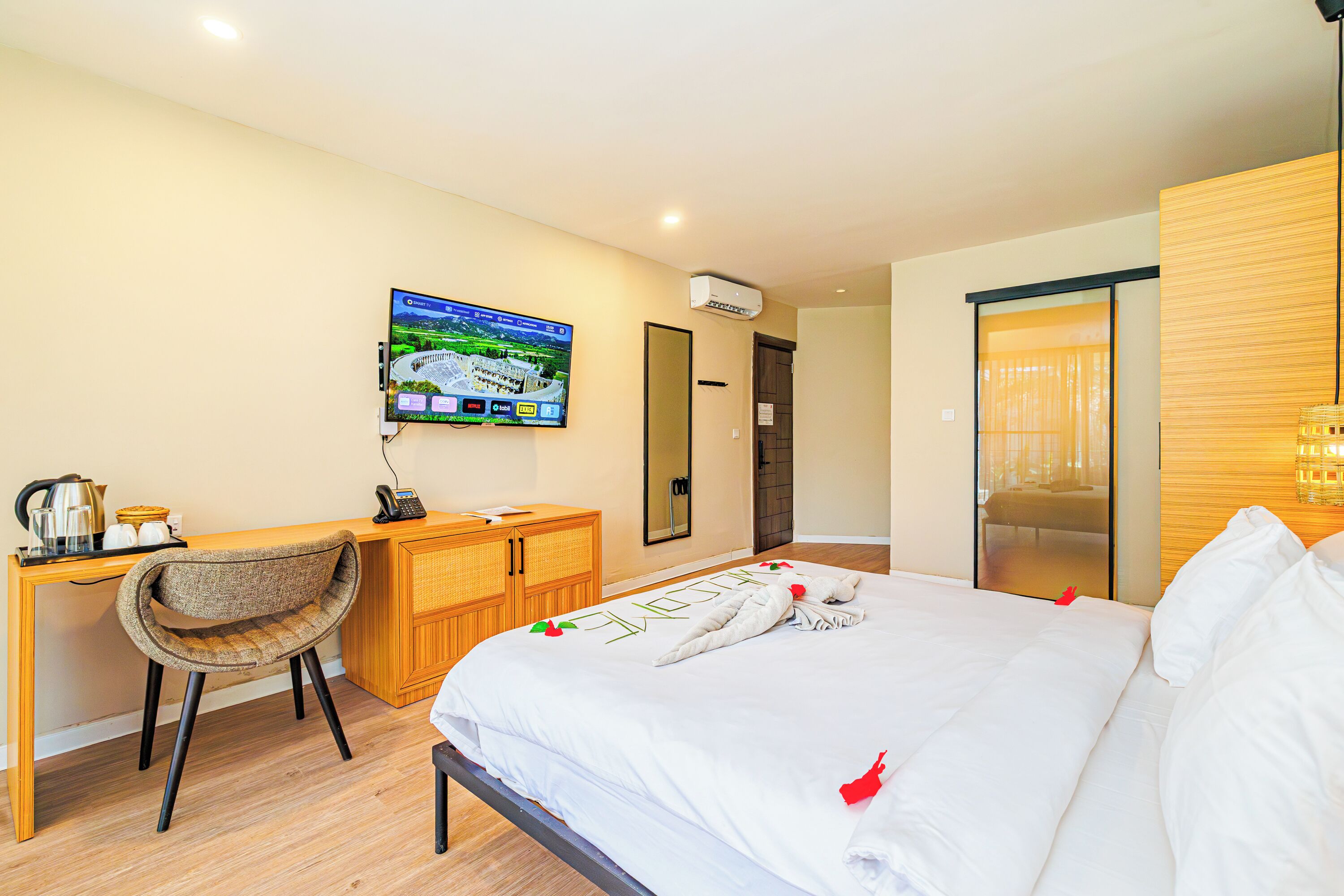 Una habitación de hotel con cama, escritorio, silla, televisor y armario de madera.