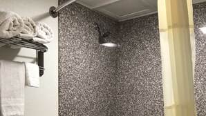 A bathroom with a shower, a toilet, and a towel rack. - Best Budget Inn - Abilene (Abilene)