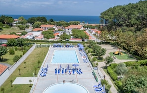 A resort with a large swimming pool, sun loungers, and a view of the sea. - Résidence Odalys Erromardie Plage (Saint-Jean-de-Luz)
