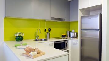 Una cocina moderna con un refrigerador de acero inoxidable, un microondas y un tostador.