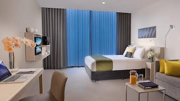 Una habitación de hotel moderna con cama, escritorio y zona de estar.