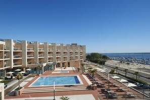 Un hôtel doté d’une piscine sur le toit, de plusieurs balcons et offrant une vue sur le port de plaisance.