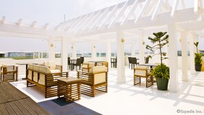 An outdoor seating area with wooden furniture and potted plants.