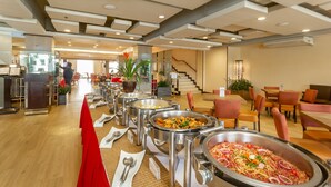 A buffet area with multiple food stations, a staircase, and seating arrangements.