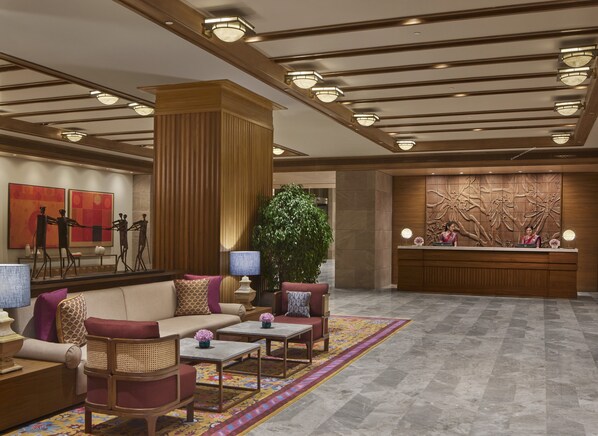 A lobby with a reception desk, seating area, and artwork.