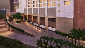 A modern hotel with a grid of rooms, a prominent 'TAJ' sign, and a landscaped courtyard. - Taj City Centre New Town Kolkata (Barasat)