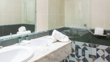 Un baño con un espejo grande, dos lavamanos y una zona de ducha.