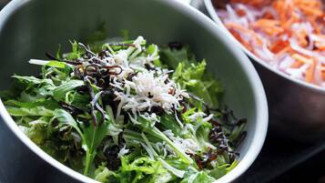 A bowl of salad with mixed greens and shredded cheese.