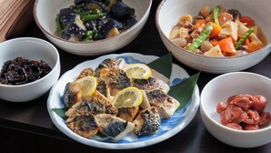 A table with various dishes, including fish, vegetables, and possibly some pickled items. - Hotel Vista Ebina (Ebina)