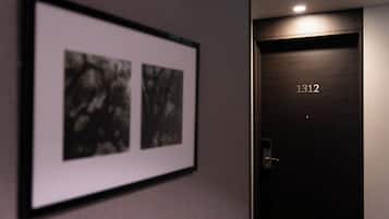 A framed photograph on the wall and a dark wooden door with the number '1312' on it.