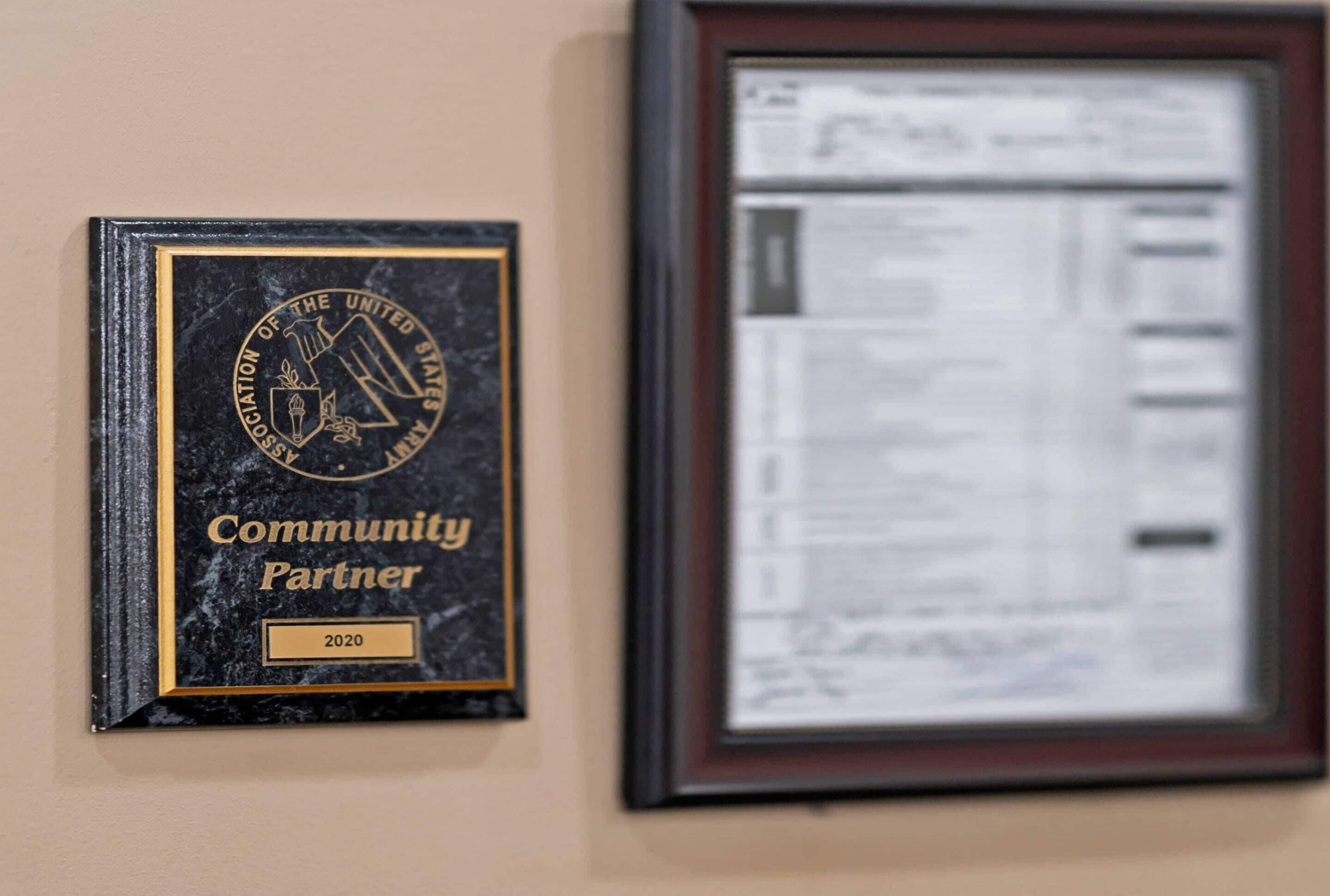 A framed document and a plaque on a wall.