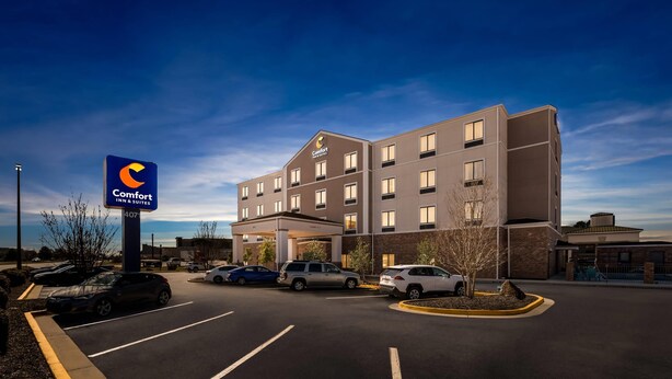A Comfort Inn & Suites hotel with a parking lot, multiple vehicles, and a clear sky. - Comfort Inn & Suites Augusta West Near Fort Gordon (Augusta)
