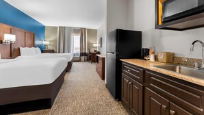 A hotel room with a bed, a desk, a kitchenette, and a view of the city. - Comfort Inn & Suites Augusta West Near Fort Gordon (Augusta)