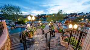 A stone staircase leading to a pool area with outdoor seating and potted plants. - The Springs Resort & Spa (Pagosa Springs)