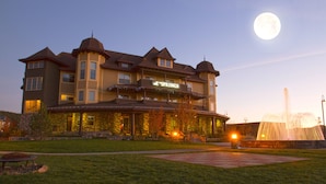 Een groot, meerhoog hotel met een opvallend 'SPRINGS' bord, een verzorgd gazon en een fontein.