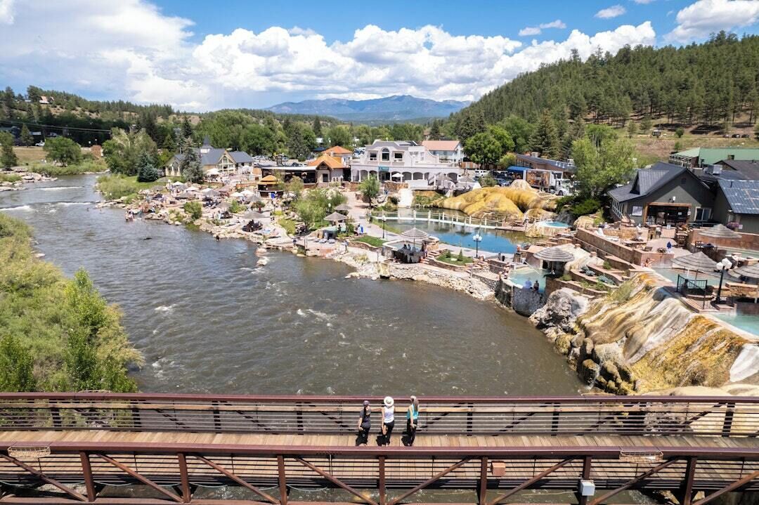 A riverside town with a bridge, buildings, and a river.